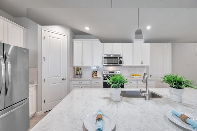 kitchen with white cabinetry, hanging light fixtures, stainless steel appliances, and sink