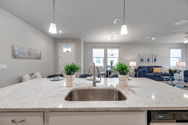 kitchen with pendant lighting, a kitchen island with sink, and sink