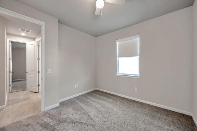 unfurnished room featuring light colored carpet, visible vents, baseboards, and light tile patterned floors