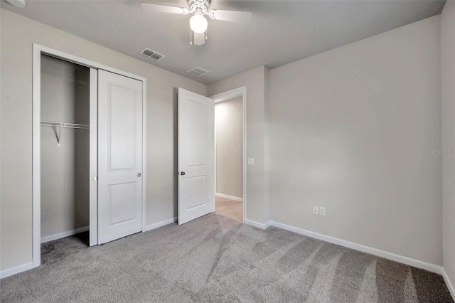 unfurnished bedroom featuring light colored carpet, ceiling fan, and a closet