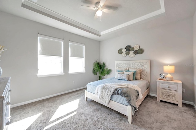 bedroom with ornamental molding, light carpet, and a tray ceiling