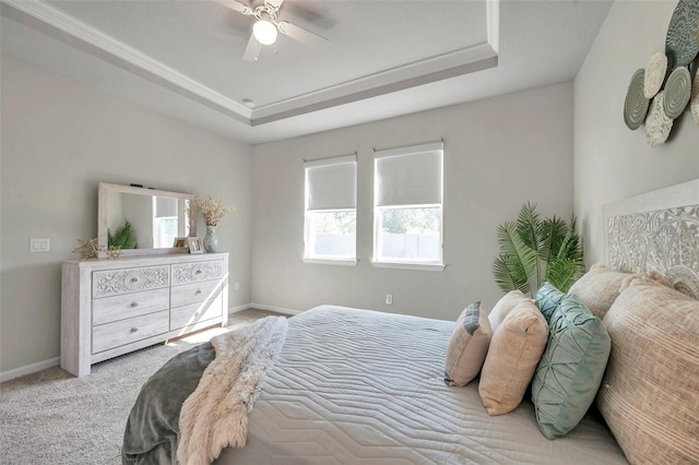 bedroom with a tray ceiling, carpet, and baseboards