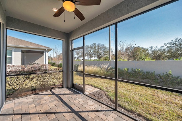 unfurnished sunroom featuring ceiling fan