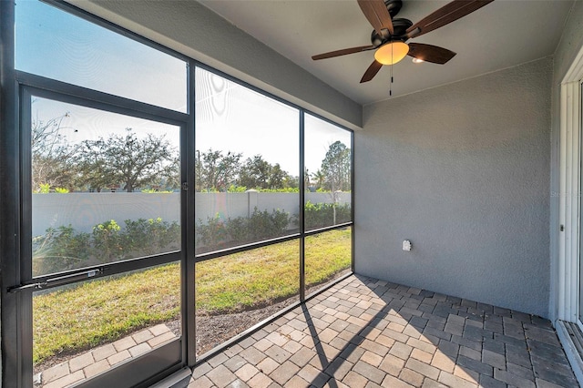 sunroom / solarium featuring a ceiling fan