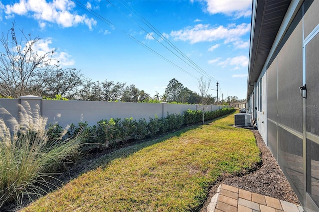 view of yard featuring a fenced backyard and central air condition unit