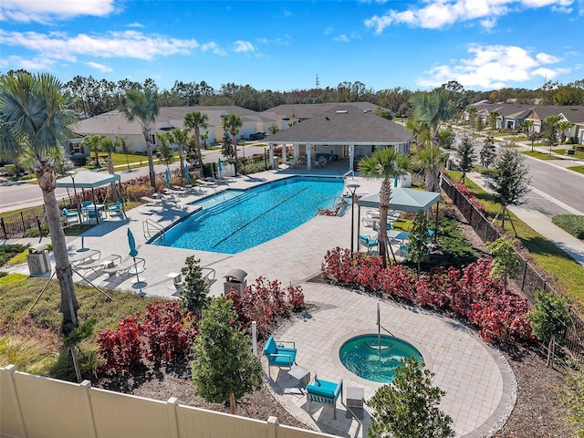 pool featuring a patio area, a residential view, fence, and a community hot tub