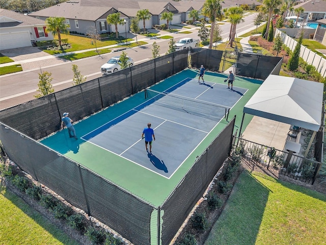 view of sport court with a residential view and fence