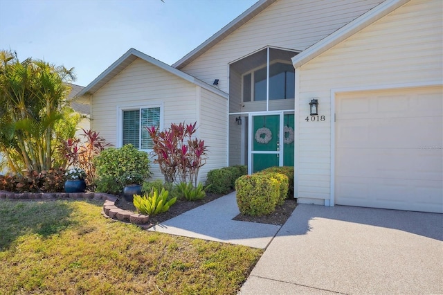 view of exterior entry featuring a garage and a yard