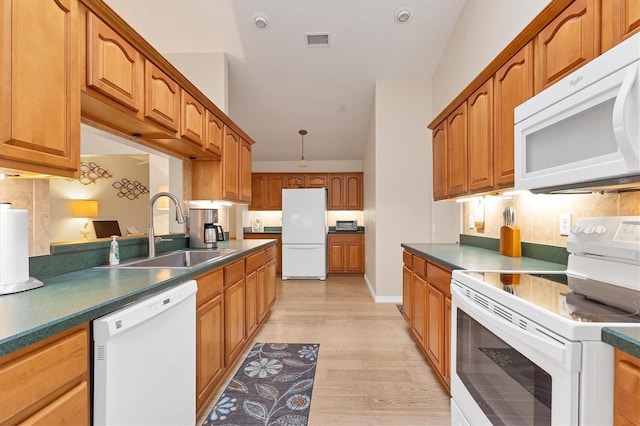 kitchen with sink, decorative backsplash, white appliances, and light wood-type flooring