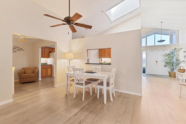 dining space featuring light hardwood / wood-style flooring, high vaulted ceiling, and ceiling fan