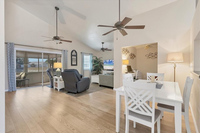 dining space with high vaulted ceiling and light wood-type flooring