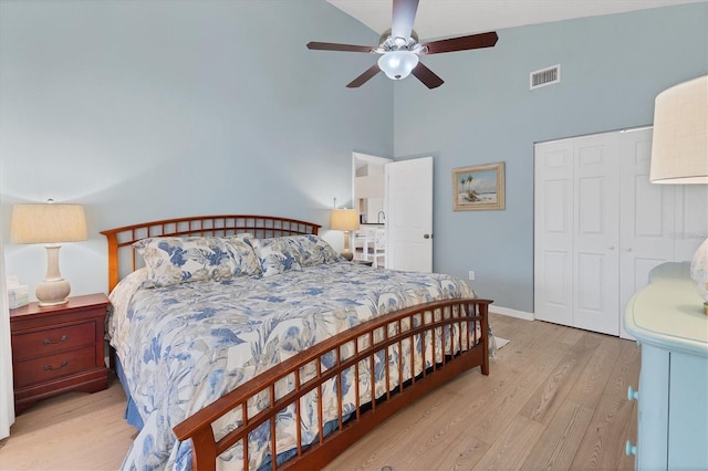 bedroom featuring a closet, ceiling fan, high vaulted ceiling, and light hardwood / wood-style flooring