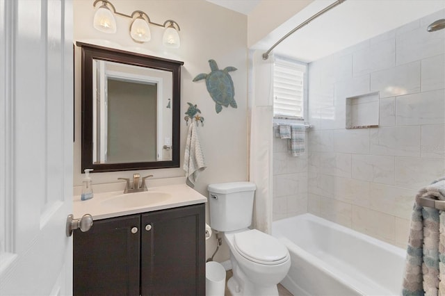 full bathroom featuring tiled shower / bath, vanity, and toilet