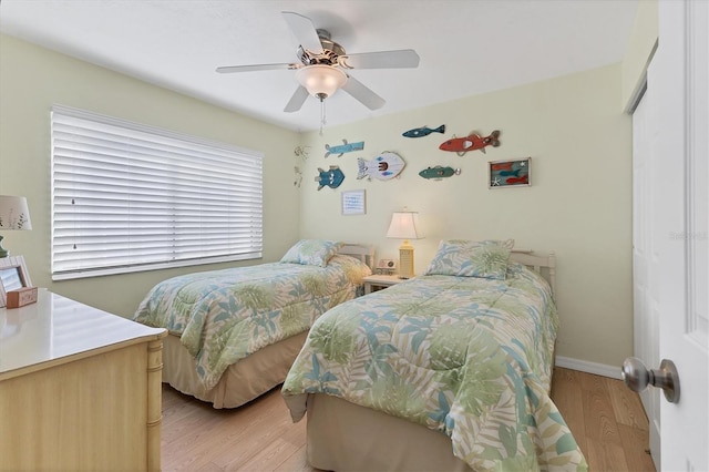 bedroom featuring ceiling fan, light hardwood / wood-style floors, and a closet