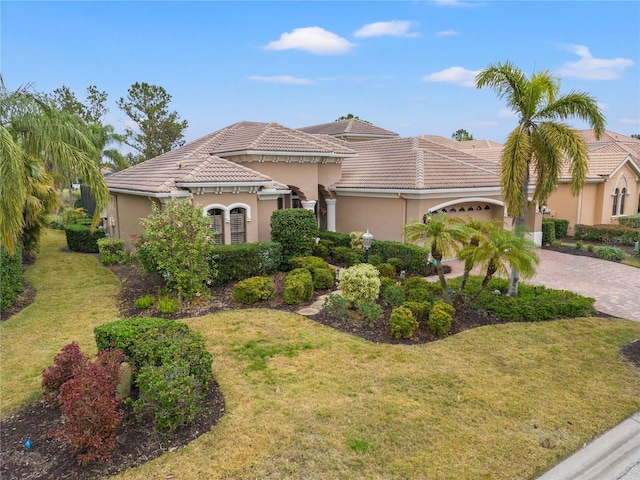 mediterranean / spanish-style house with a garage and a front yard