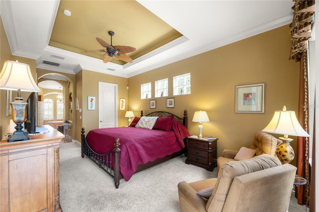 bedroom featuring crown molding, ceiling fan, a raised ceiling, and light carpet