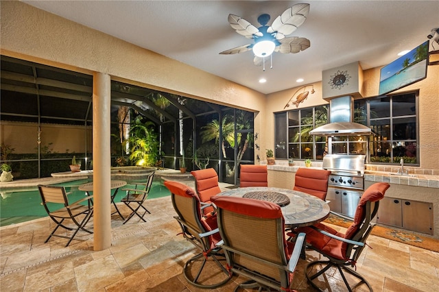 view of patio featuring area for grilling, sink, a pool with hot tub, ceiling fan, and glass enclosure