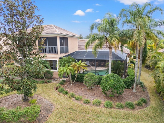 back of property featuring a lanai and a yard