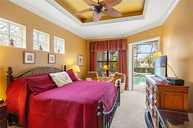 carpeted bedroom with ornamental molding, access to exterior, ceiling fan, and a tray ceiling