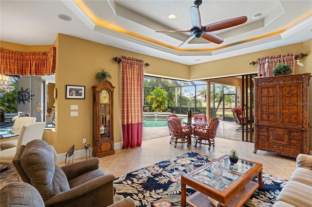 tiled living room featuring a tray ceiling and ceiling fan