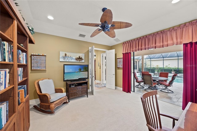 sitting room with ceiling fan and light colored carpet