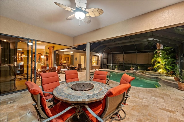 view of patio / terrace featuring a lanai, ceiling fan, and a pool with hot tub