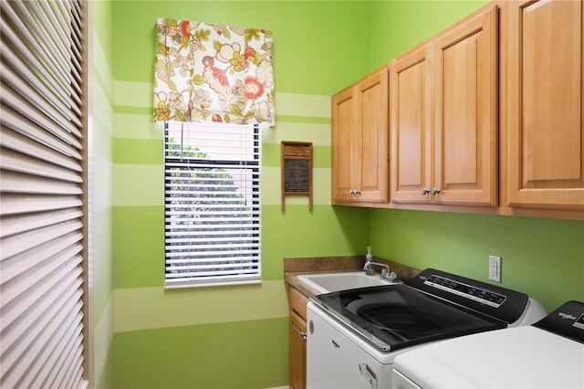 washroom with sink, cabinets, and washer and dryer