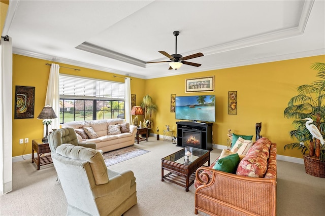 living room with crown molding, light colored carpet, a raised ceiling, and ceiling fan