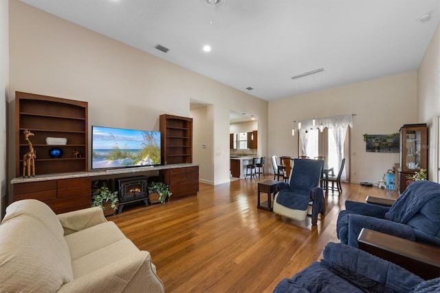 living room with a towering ceiling and light wood-type flooring