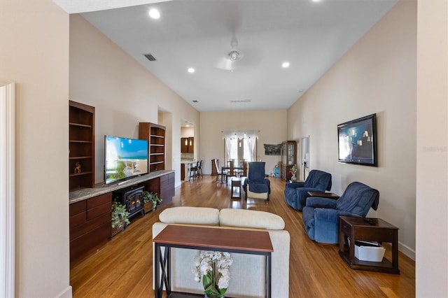 living room with built in features and light hardwood / wood-style floors