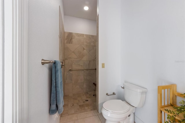 bathroom with a tile shower, tile patterned flooring, and toilet