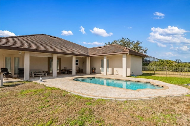 rear view of property featuring french doors, a yard, a fenced in pool, and a patio