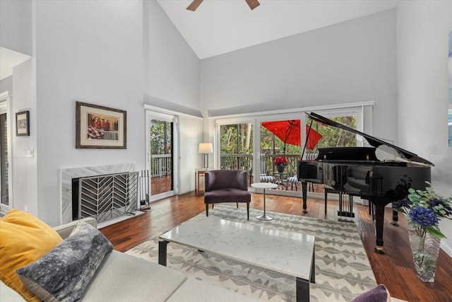 living area featuring hardwood / wood-style flooring, a high end fireplace, high vaulted ceiling, and plenty of natural light