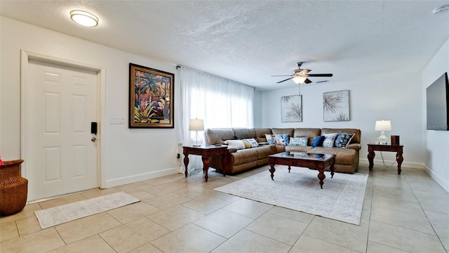 tiled living room featuring a textured ceiling and ceiling fan