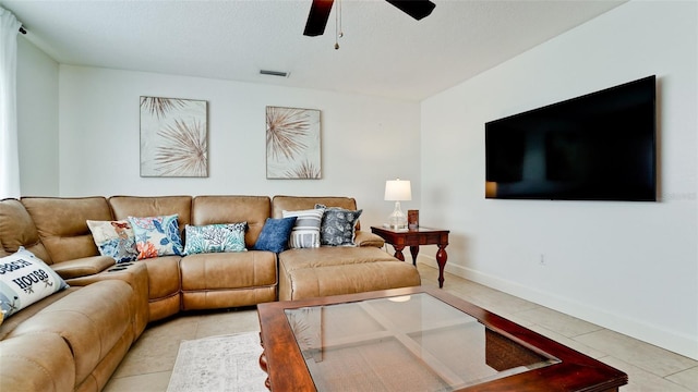 living room with light tile patterned flooring, ceiling fan, and a textured ceiling