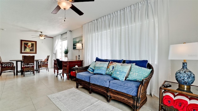 living room with ceiling fan, a textured ceiling, and light tile patterned floors