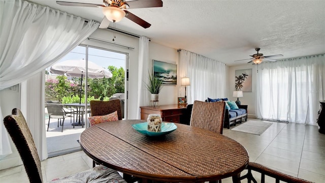 tiled dining space featuring ceiling fan and a textured ceiling