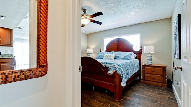 bedroom featuring multiple windows, ceiling fan, and a textured ceiling