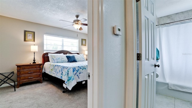 carpeted bedroom featuring ceiling fan and a textured ceiling