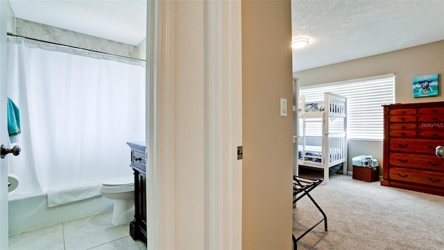 full bathroom featuring toilet, a textured ceiling, vanity, shower / bath combo, and tile patterned flooring