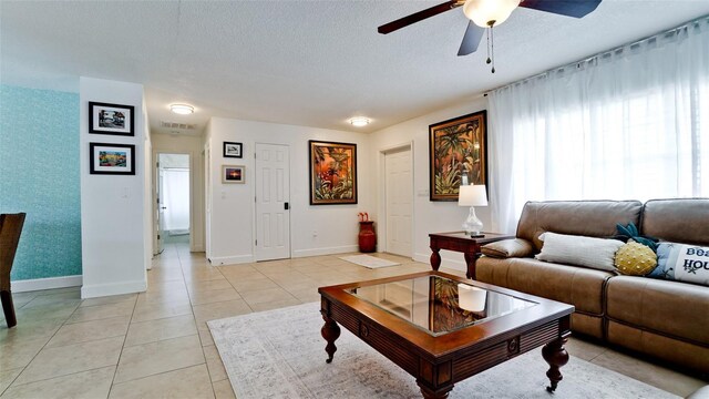 tiled living room with ceiling fan and a textured ceiling