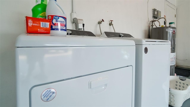 laundry room with water heater and washer and dryer