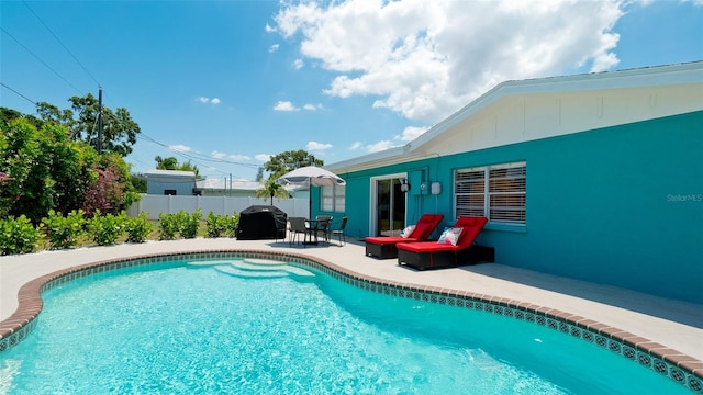 view of pool featuring area for grilling and a patio