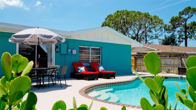 exterior space featuring a fenced in pool and a patio