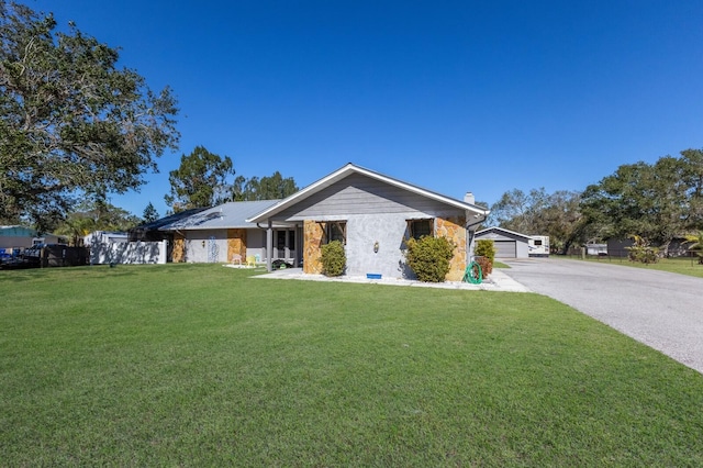 ranch-style home featuring a garage and a front lawn