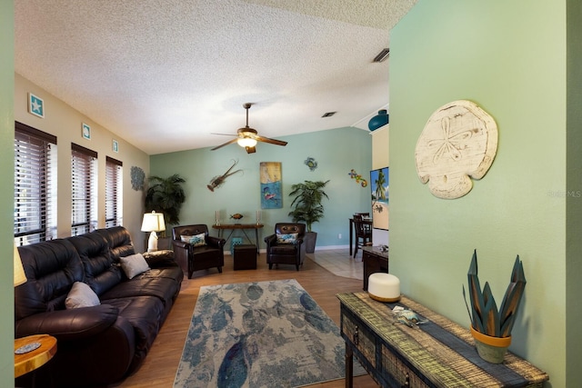 living room with a textured ceiling, light hardwood / wood-style flooring, and ceiling fan