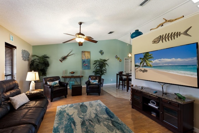 living room featuring lofted ceiling, light hardwood / wood-style floors, and a textured ceiling