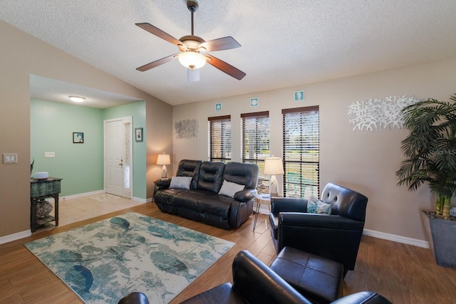 living room featuring lofted ceiling, ceiling fan, hardwood / wood-style flooring, and a textured ceiling