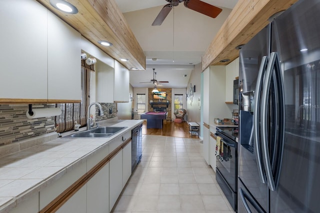 kitchen with tasteful backsplash, white cabinetry, sink, tile counters, and black appliances