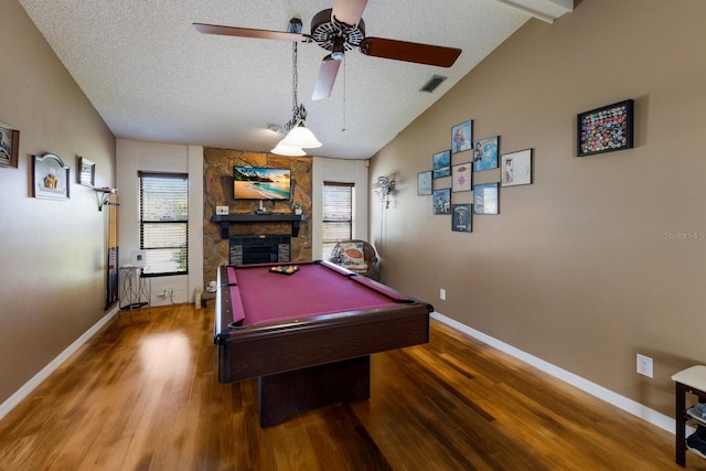 game room featuring lofted ceiling, hardwood / wood-style flooring, a fireplace, a textured ceiling, and pool table